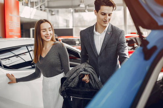 Couple buying the car. Pair in a car salon. Husband with vife choose the automobile