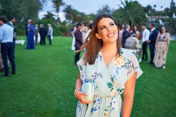 Fototapeta premium Young beautiful and elegant woman with wedding guest dress smiling happy and cheerful