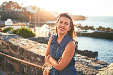 Beautiful young woman walking on beach promenade enjoying ocean view smiling happy on summer vacation © Krakenimages.com