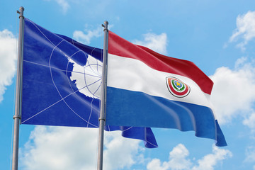 Paraguay and Antarctica flags waving in the wind against white cloudy blue sky together. Diplomacy concept, international relations.
