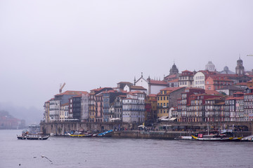 Naklejka premium December 8, 2019 Porto, Portugal. People and cars crossing the port of Porto a day of rain and fog