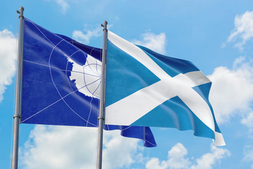 Scotland and Antarctica flags waving in the wind against white cloudy blue sky together. Diplomacy concept, international relations.