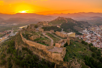 Aerial sunset view of Sagunto, huge fortress stretching across the mountain range north of Valencia Spain
