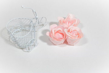white decorative Bicycle and three pink roses on a white background, holiday, Valentine's day, wedding