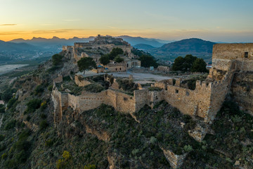 Fototapeta na wymiar Aerial sunset view of Sagunto, huge fortress stretching across the mountain range north of Valencia Spain