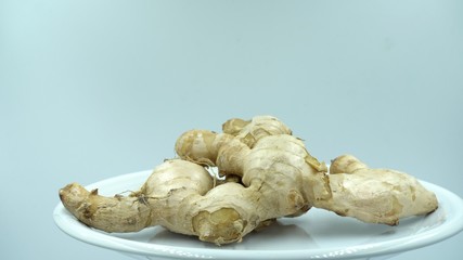 ginger white raw background rotating in white plate.