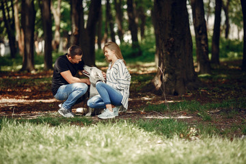 Fototapeta premium Couple in a forest. Pair playing with a cute dog