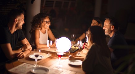 Beautiful family on dinner talking and smiling at terrace