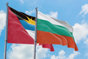 Bulgaria and Antigua and Barbuda flags waving in the wind against white cloudy blue sky together. Diplomacy concept, international relations.