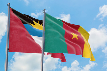 Cameroon and Antigua and Barbuda flags waving in the wind against white cloudy blue sky together. Diplomacy concept, international relations.