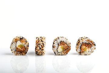 Four Japanese maki sushi rolls in a row with salmon, sesame, cucumber and cream cheese  isolated on white background. Side view