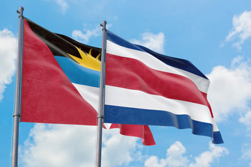Fototapeta na wymiar Costa Rica and Antigua and Barbuda flags waving in the wind against white cloudy blue sky together. Diplomacy concept, international relations.