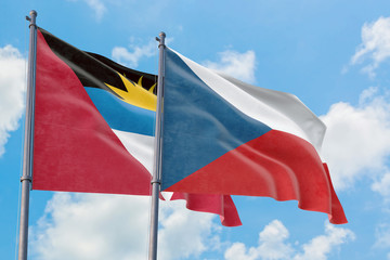Czech Republic and Antigua and Barbuda flags waving in the wind against white cloudy blue sky together. Diplomacy concept, international relations.