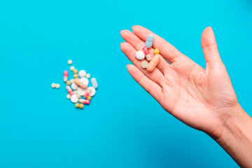 Pills in hands on a blue background.