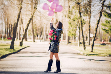 Beautiful girl in a white sweater. Woman in a spring park. Lady with bouquet of flowers