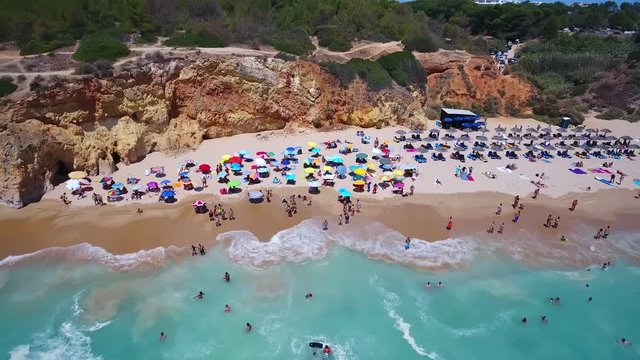 Aerial top view of tourists resting on the beach Alemao Vau, Boia, tres irmaos, Portimao Algarve coast. Portugal.