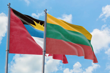 Lithuania and Antigua and Barbuda flags waving in the wind against white cloudy blue sky together. Diplomacy concept, international relations.