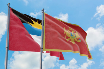 Montenegro and Antigua and Barbuda flags waving in the wind against white cloudy blue sky together. Diplomacy concept, international relations.