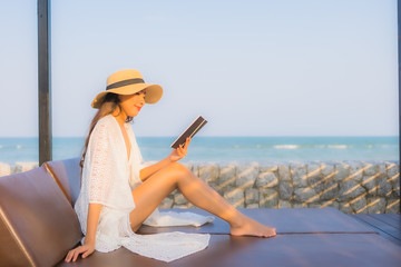 Portrait young asian woman read book around beach sea ocean