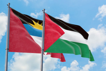 Palestine and Antigua and Barbuda flags waving in the wind against white cloudy blue sky together. Diplomacy concept, international relations.