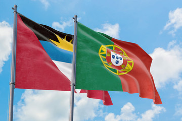 Portugal and Antigua and Barbuda flags waving in the wind against white cloudy blue sky together. Diplomacy concept, international relations.