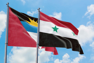 Syria and Antigua and Barbuda flags waving in the wind against white cloudy blue sky together....