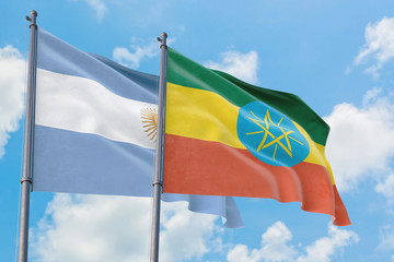 Ethiopia and Argentina flags waving in the wind against white cloudy blue sky together. Diplomacy concept, international relations.