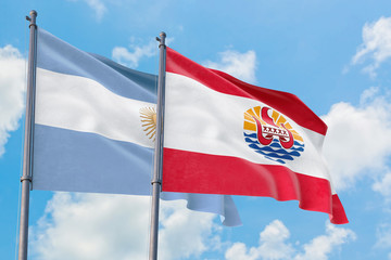 Fototapeta na wymiar French Polynesia and Argentina flags waving in the wind against white cloudy blue sky together. Diplomacy concept, international relations.