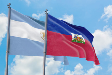 Haiti and Argentina flags waving in the wind against white cloudy blue sky together. Diplomacy concept, international relations.