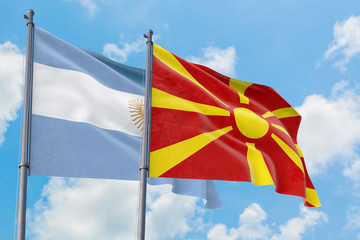 Macedonia and Argentina flags waving in the wind against white cloudy blue sky together. Diplomacy concept, international relations.