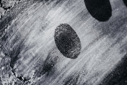 fingerprint on white ground smeared white powder on black clean background, place for inscription, top view, flat
