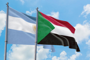 Sudan and Argentina flags waving in the wind against white cloudy blue sky together. Diplomacy concept, international relations.