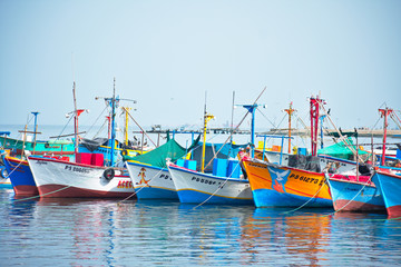 Fototapeta na wymiar Pastel colorful fishing boats floating in the ocean in Paracas Peru