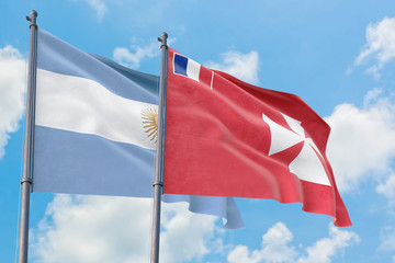 Wallis And Futuna and Argentina flags waving in the wind against white cloudy blue sky together. Diplomacy concept, international relations.