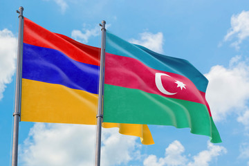 Azerbaijan and Armenia flags waving in the wind against white cloudy blue sky together. Diplomacy concept, international relations.