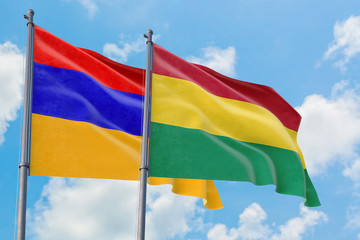 Bolivia and Armenia flags waving in the wind against white cloudy blue sky together. Diplomacy concept, international relations.
