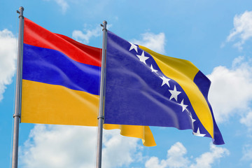Bosnia Herzegovina and Armenia flags waving in the wind against white cloudy blue sky together. Diplomacy concept, international relations.