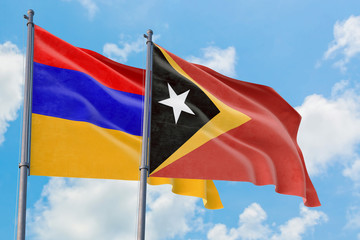 East Timor and Armenia flags waving in the wind against white cloudy blue sky together. Diplomacy concept, international relations.