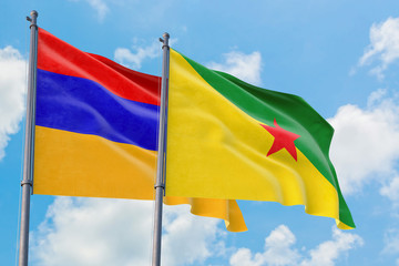 French Guiana and Armenia flags waving in the wind against white cloudy blue sky together. Diplomacy concept, international relations.