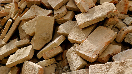 slagheap with broken bricks from a destroyed wall after a demolition or an earthquake with different forms and shapes