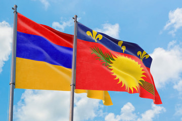 Guadeloupe and Armenia flags waving in the wind against white cloudy blue sky together. Diplomacy concept, international relations.