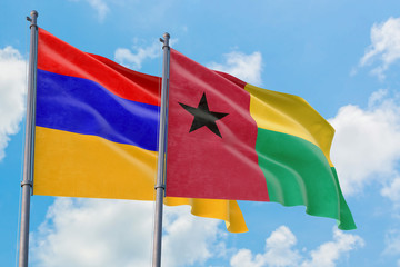 Guinea Bissau and Armenia flags waving in the wind against white cloudy blue sky together. Diplomacy concept, international relations.