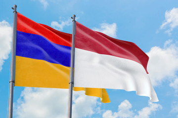 Fototapeta na wymiar Indonesia and Armenia flags waving in the wind against white cloudy blue sky together. Diplomacy concept, international relations.