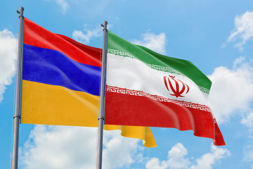 Iran and Armenia flags waving in the wind against white cloudy blue sky together. Diplomacy concept, international relations.