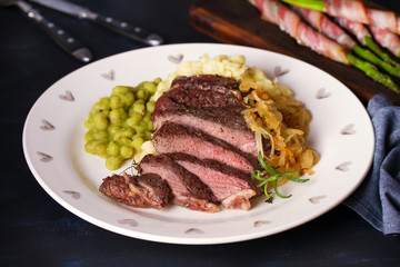 Beef steak fillet with mash on plate. Bacon wrapped asparagus. Horizontal image