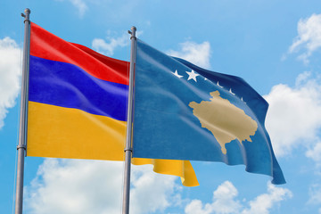 Kosovo and Armenia flags waving in the wind against white cloudy blue sky together. Diplomacy concept, international relations.