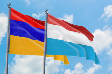 Luxembourg and Armenia flags waving in the wind against white cloudy blue sky together. Diplomacy concept, international relations.