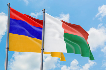 Madagascar and Armenia flags waving in the wind against white cloudy blue sky together. Diplomacy concept, international relations.