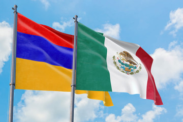 Mexico and Armenia flags waving in the wind against white cloudy blue sky together. Diplomacy concept, international relations.