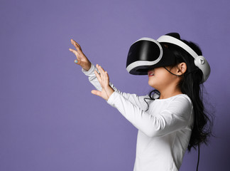 Young girl kid child play virtual reality game hold  vr glasses and surprised. Cyber space and virtual gaming